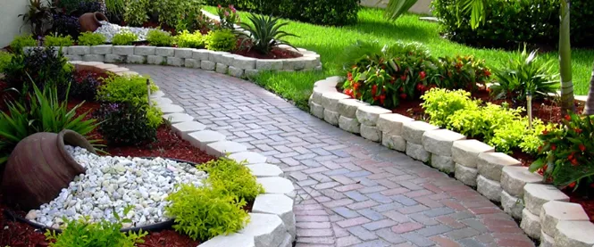 Designed landscape bed beside a stone-walled patio