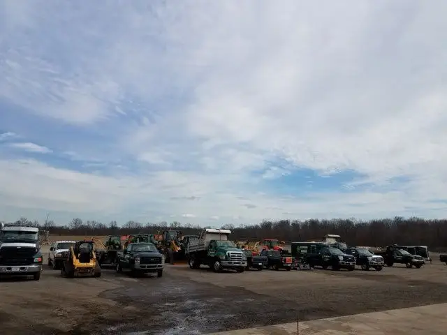 Fleet of KBK Landscaping trucks and equipment lined up at the company yard