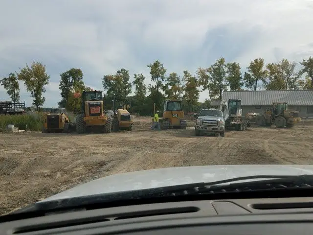 Wheel loaders and trucks staged on a graded dirt job site